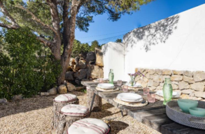Exterior view of Casa Nashamena in San Miguel, Ibiza, showcasing a private pool, lush gardens, and panoramic views.