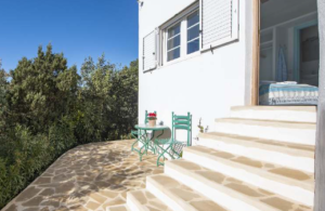 Exterior view of Casa Nashamena in San Miguel, Ibiza, showcasing a private pool, lush gardens, and panoramic views.
