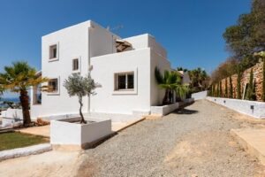Exterior view of Luxury Casa Flamenc, Ibiza, showcasing the modern architecture, garage, garden, and entrance.