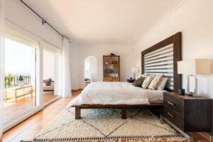 Charming bedroom at Luxury Casa Flamenc, Ibiza, featuring a king-size bed, panoramic views, and a private terrace.