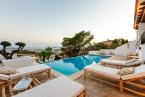 Private pool at Luxury Casa Flamenc, Ibiza, with comfortable lounge chairs for sunbathing and stunning sea views.