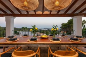 Elegant outdoor dining area at Luxury Casa Flamenc, Ibiza, featuring a stylish dining table with stunning views of the sea and nature.